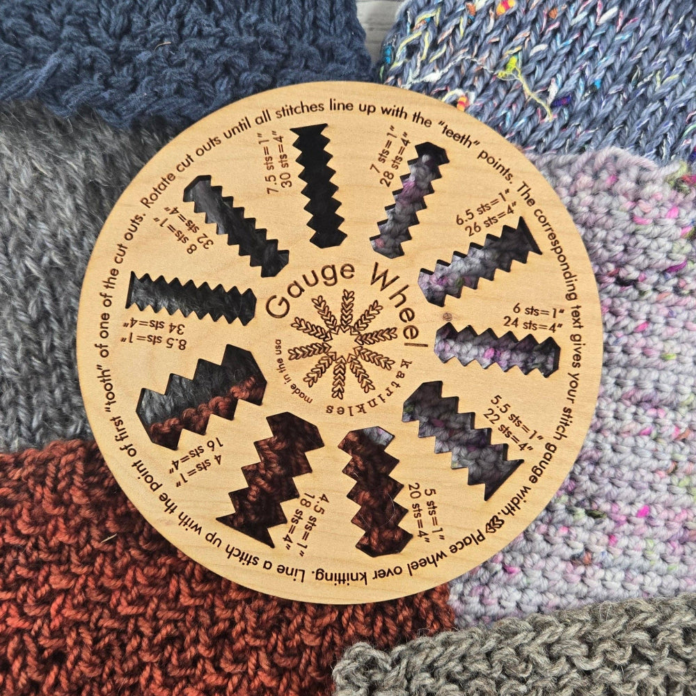 Wooden wheel with different gauge cutouts on top of multicolored knit swatches