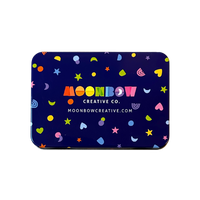 Tin with colorful patterns and 'Moonbow Creative Co.' branding on a dark blue background