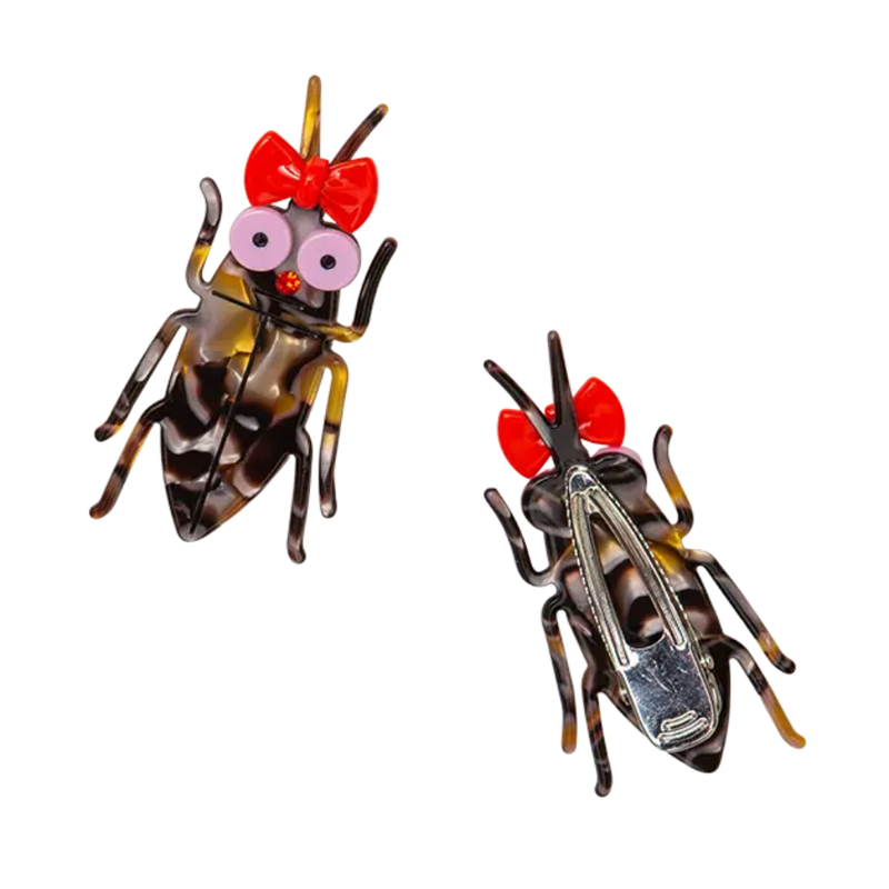 Two cockroach clips with red bows and googly eyes