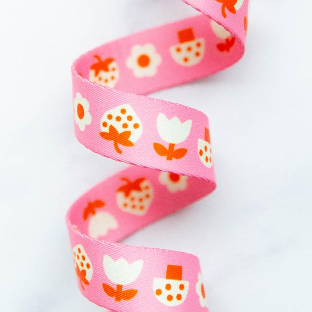 Pink webbing with floral pattern on a white background