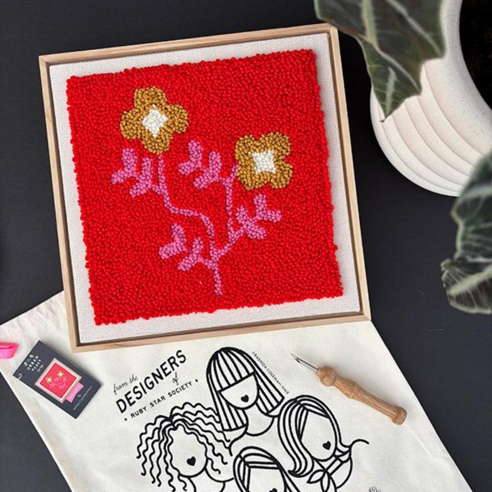 framed punch needle square with flowers on a red background