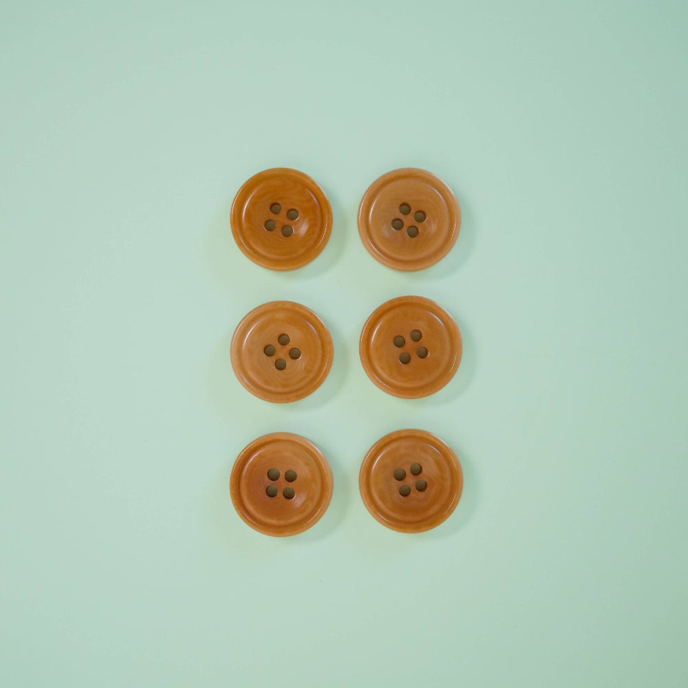 Six brown buttons arranged in two rows on a light green background