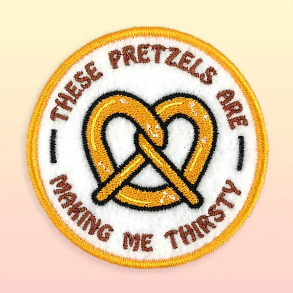 Embroidered patch with pretzels and text on a beige background