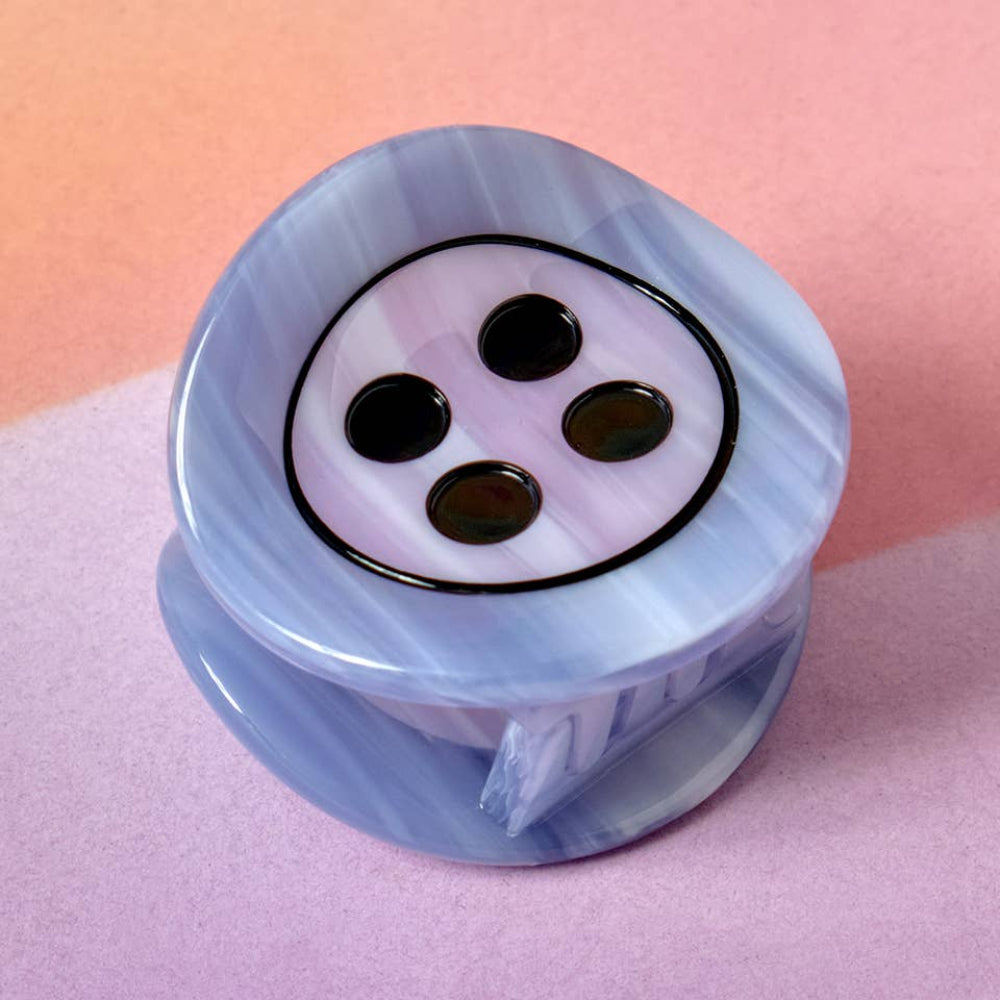 Decorative button with a marbled blue and pink design on a pink background