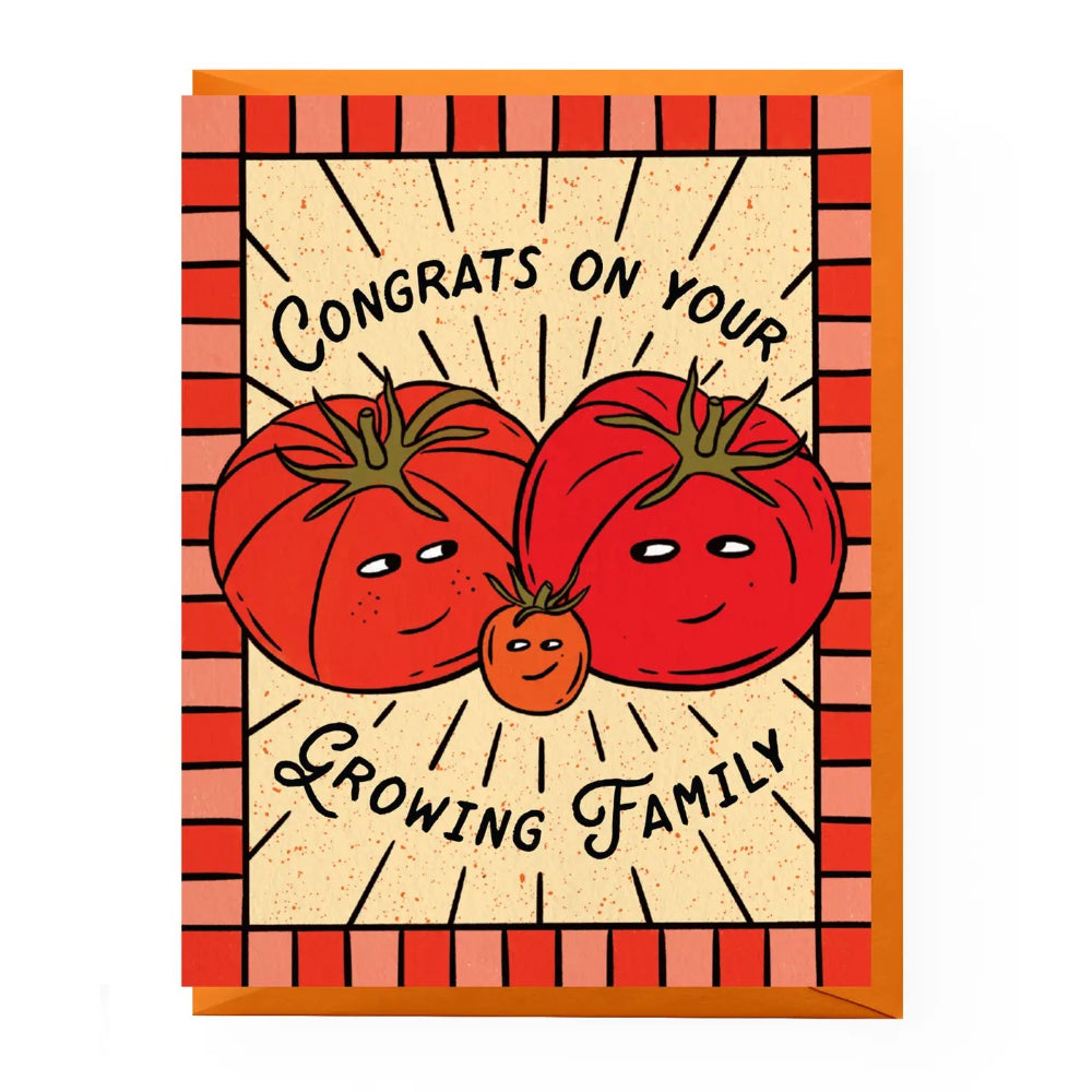 A greeting card with an illustrated design featuring three smiling tomatoes and the text 'Congrats on your Growing Family' on a cream background with a red-orange striped border, shown with an orange envelope behind it.