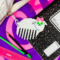 Decorative comb with dog character on a purple surface with stationery items
