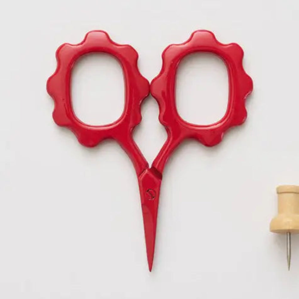 Red scissors with decorative handles on a white background