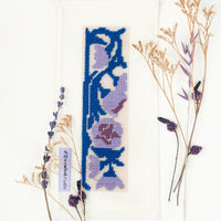 Needlepoint floral design with dried flowers on a white background