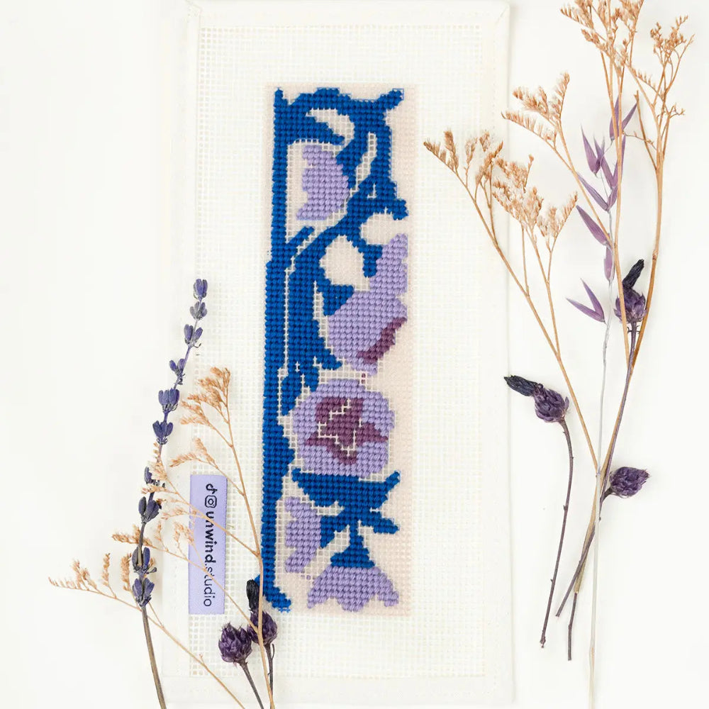 Needlepoint floral design with dried flowers on a white background