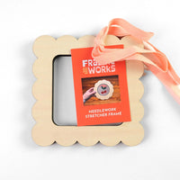 Beige needlework stretcher frame with an orange label on a white background