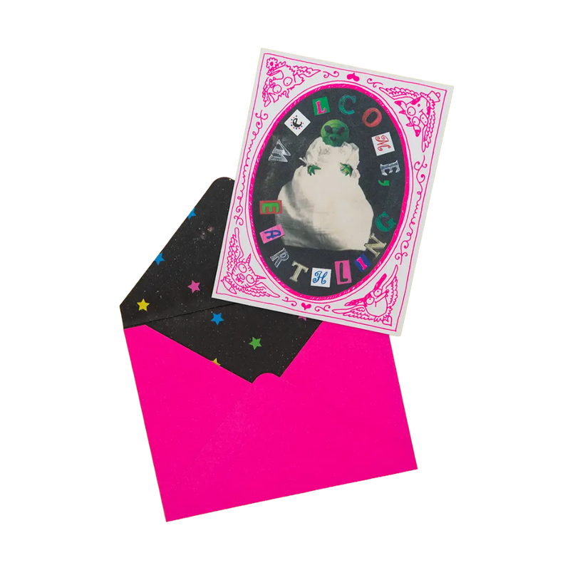 Alien wrapped in a towel on a white and pink card with pink envelope. 