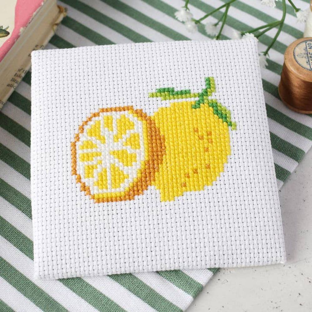 Cross-stitched lemon design on a white fabric background