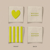 Front and back view of the labels with a heart or stripes on the front and Matchy Matchy written on the back