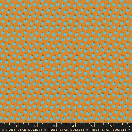 Patterned fabric with blue apples on a tan background, featuring Ruby Star Society label.
