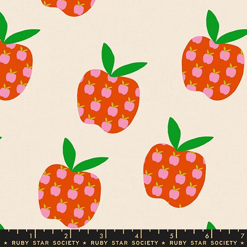 Pattern of red apples with pink centers and green leaves on a beige background, featuring Ruby Star Society label.