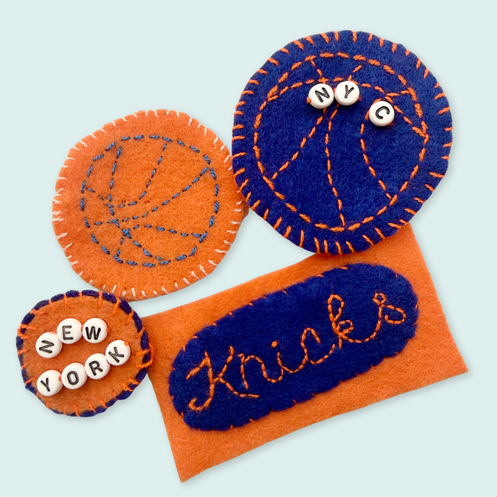 Felt New York Knicks fan accessories on a light blue background