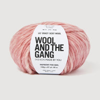 A skein of Lil' Crazy Sexy Wool by Wool and The Gang in Raspberry Pink Marl, which is a variegated pink and white colorway. 