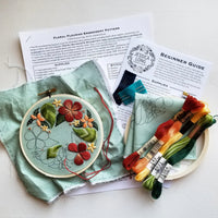 Embroidery kit with floral design, threads, instructions ,and a light blue fabric