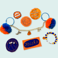 Collection of New York Knicks-themed keychains and charms on a light blue background