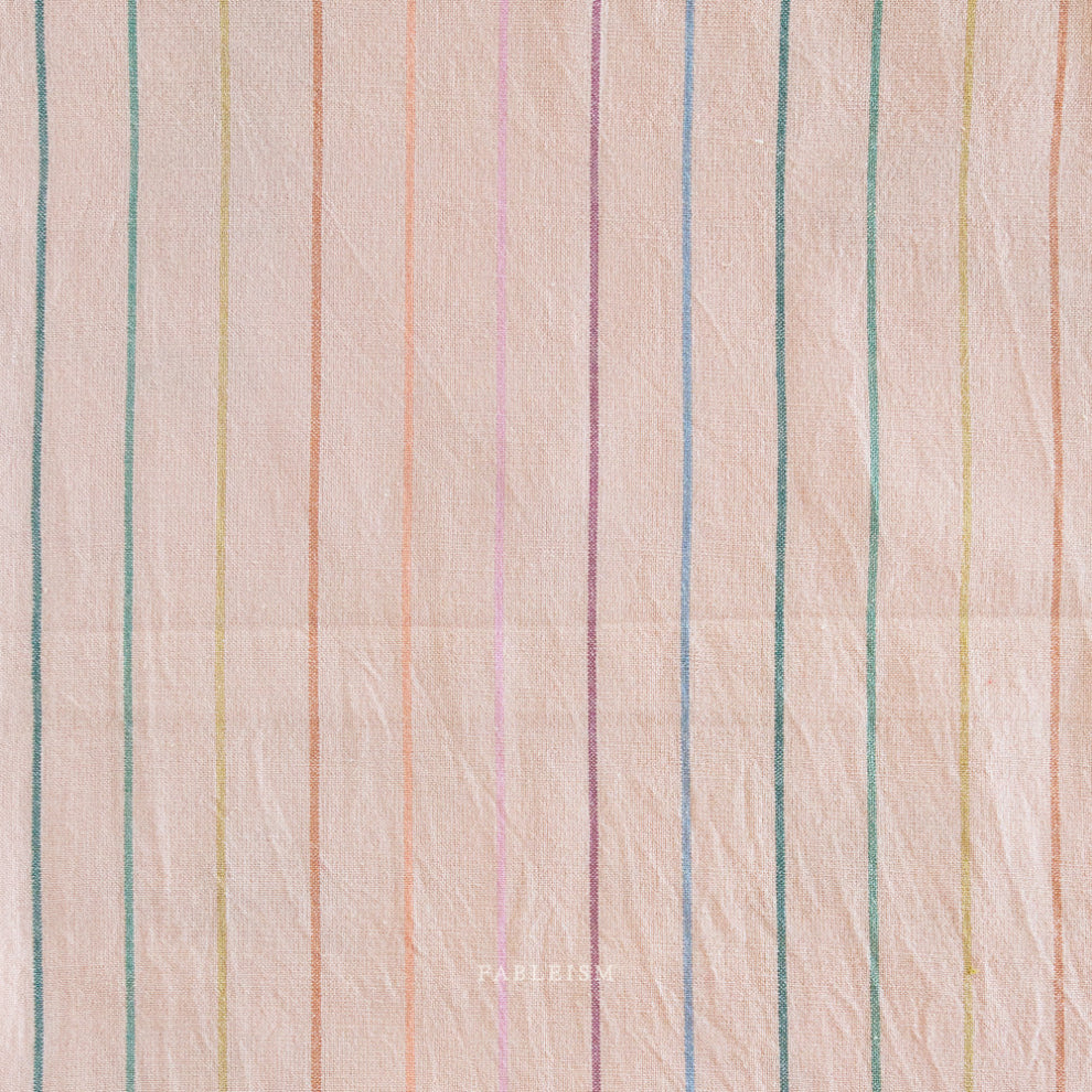 Textured fabric with multicolored vertical stripes on a light pink background