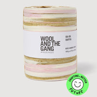 Spool of pink, white, and beige yarn with 'Wool and the Gang' label on a white background