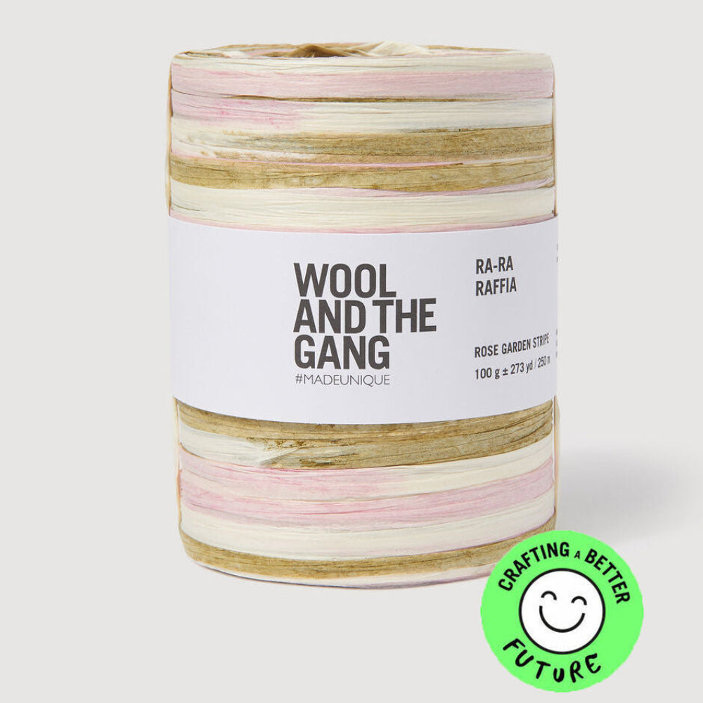Spool of pink, white, and beige yarn with 'Wool and the Gang' label on a white background