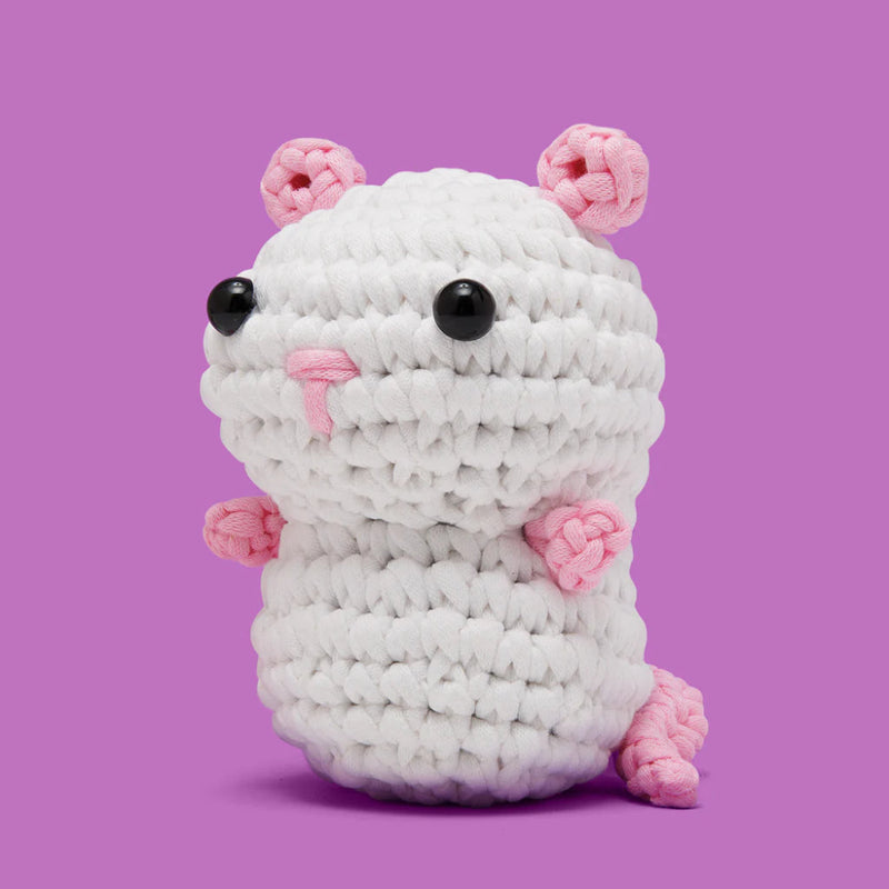 White crochet rat with pink ears and feet on a purple background