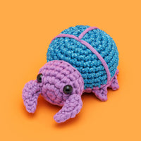 Crocheted beetle on orange background