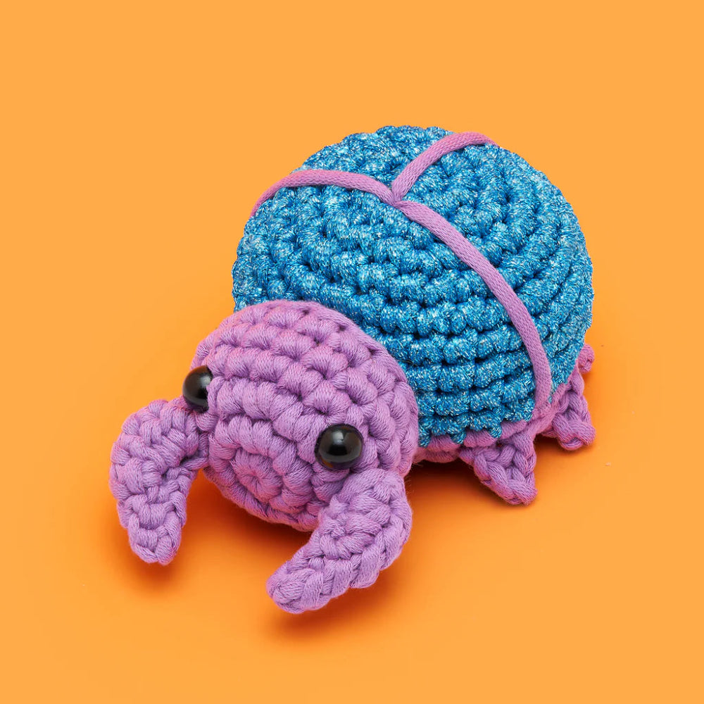 Crocheted beetle on orange background