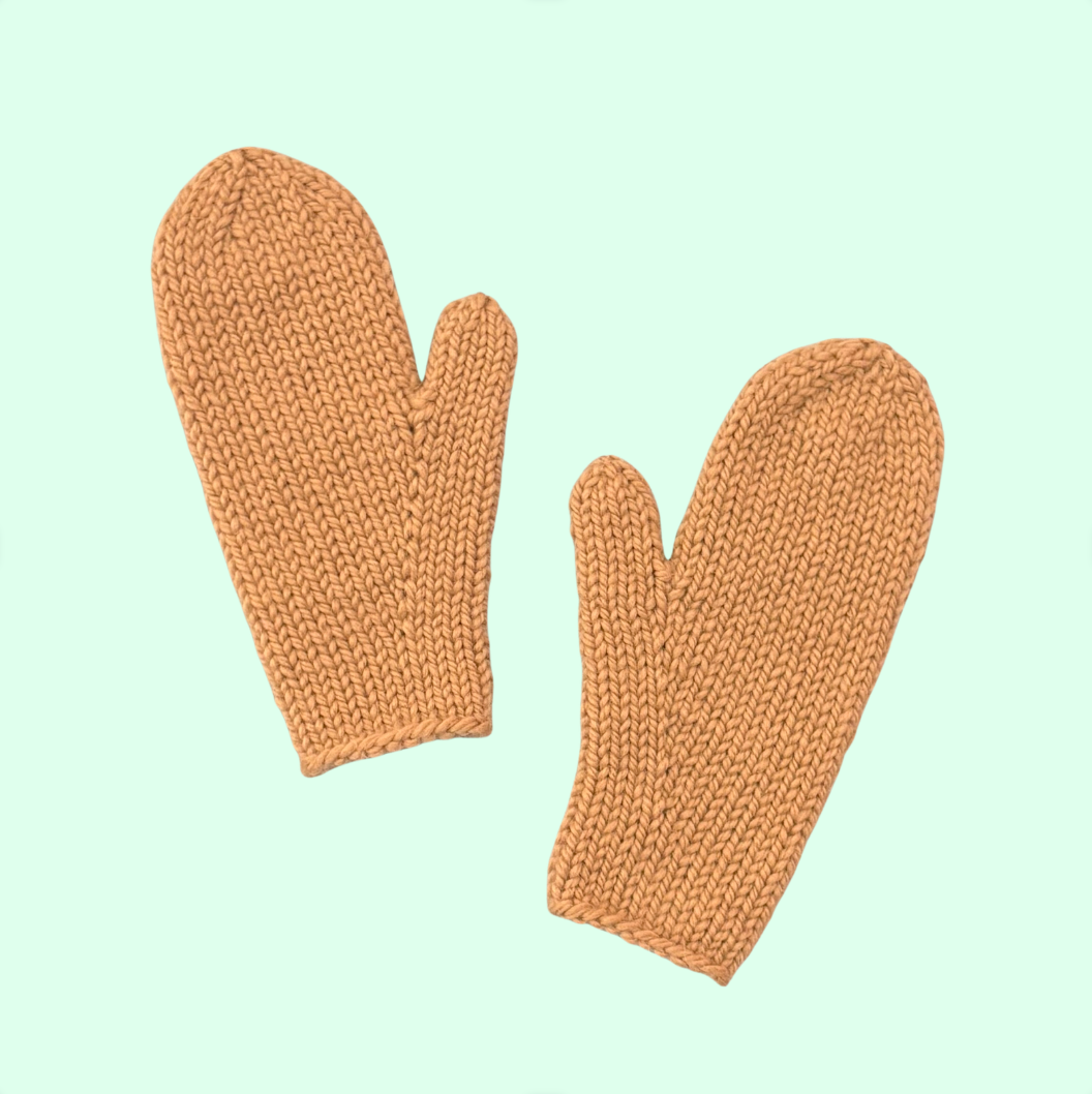Pair of knit mittens on a blue background.