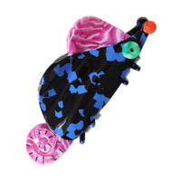 Colorful rat-shaped hair claw with pink and blue patterns on a white background