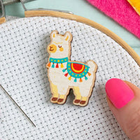 Colorful wooden alpaca on aida fabric with an embroidery hoop