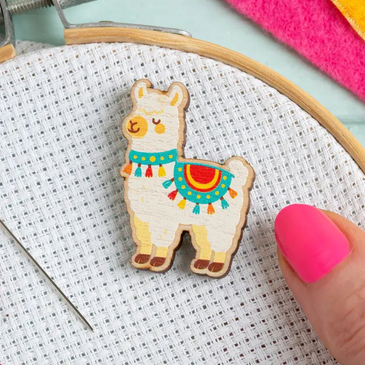 Colorful wooden alpaca on aida fabric with an embroidery hoop