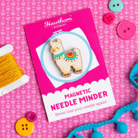 Hawthorn Magnetic Needle Minder packaging on a pink background with buttons and yarn.