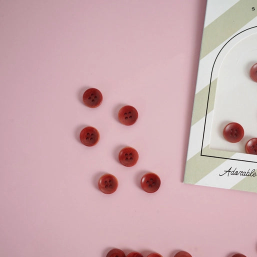 6 red buttons on a pink background