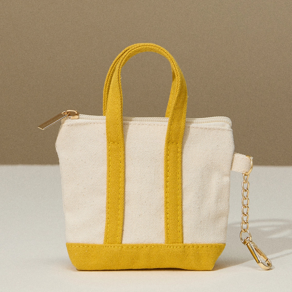 Small tote bag with yellow accents on a beige background