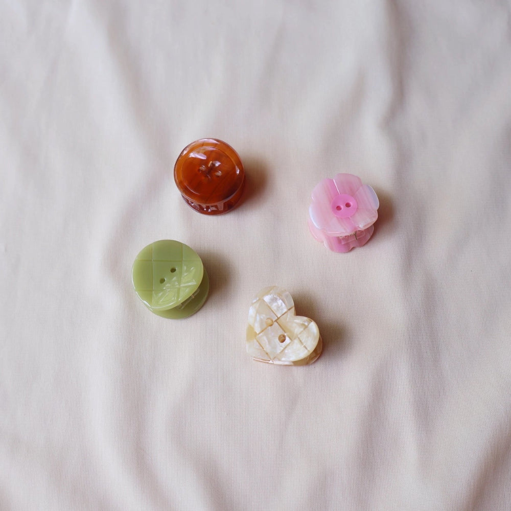 Four small decorative buttons on a light fabric background