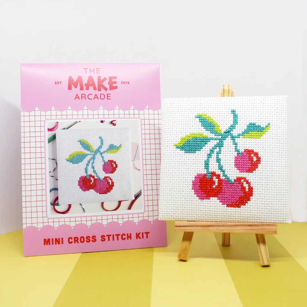 Cross stitch kit with cherry design on a white background, featuring 'The Make Arcade' packaging.