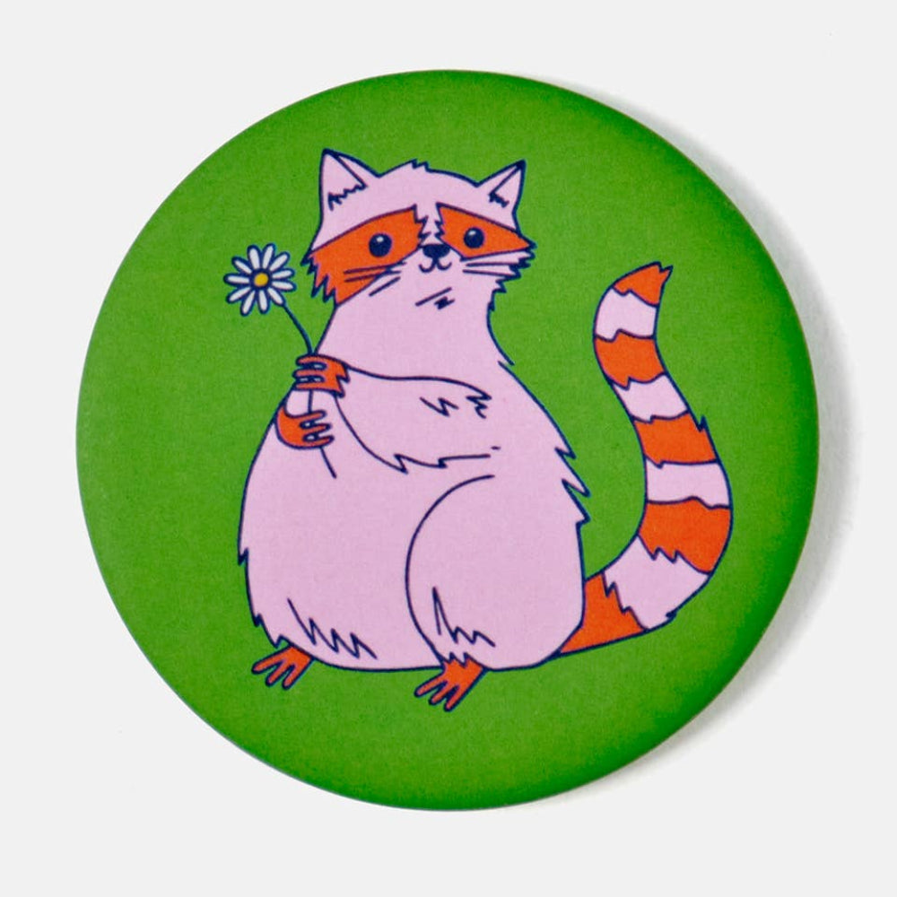 Circular green magnet with a cartoon raccoon holding a flower on a white background