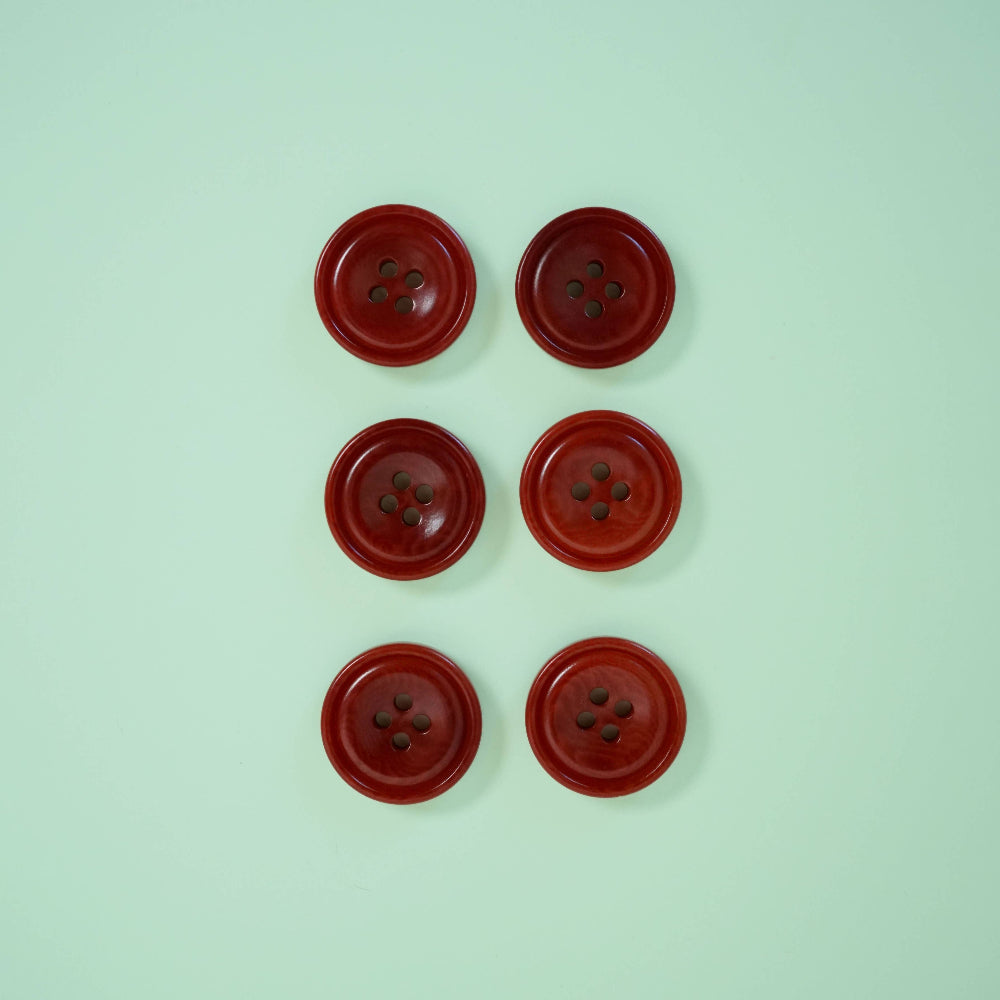 Six red buttons arranged in two rows on a light green background