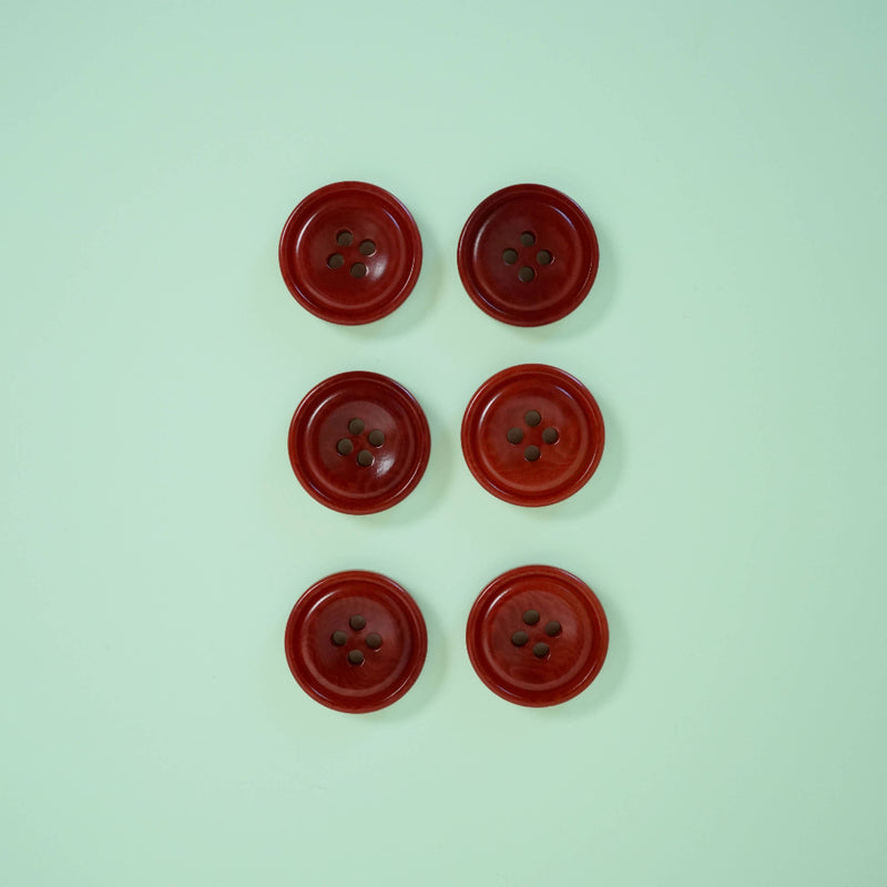 Six red buttons arranged in two rows on a light green background