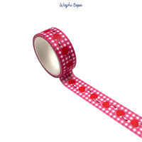 Roll of red and white checkered washi tape with cherry design on a white background