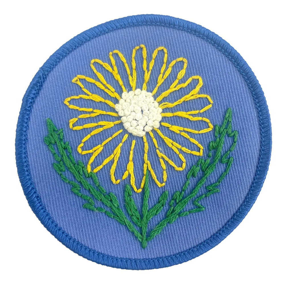 Embroidered patch with a yellow flower on a blue background