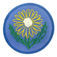 Embroidered patch with a yellow flower on a blue background