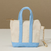 Small tote bag with blue handles and trim on a beige background