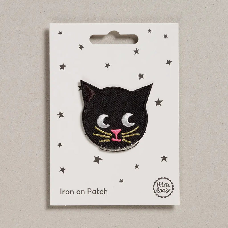Black cat iron on patch on a white card with star patterns, brand 'Petra Boase' visible.