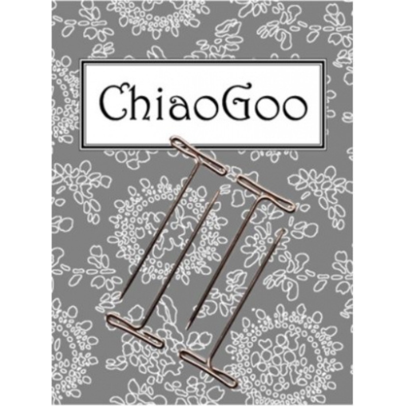 Four metal "T" shaped pins on a patterned gray background.