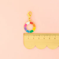 A scalloped ruler with a zipper charm on top. 