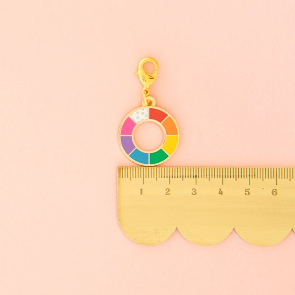 A scalloped ruler with a zipper charm on top. 