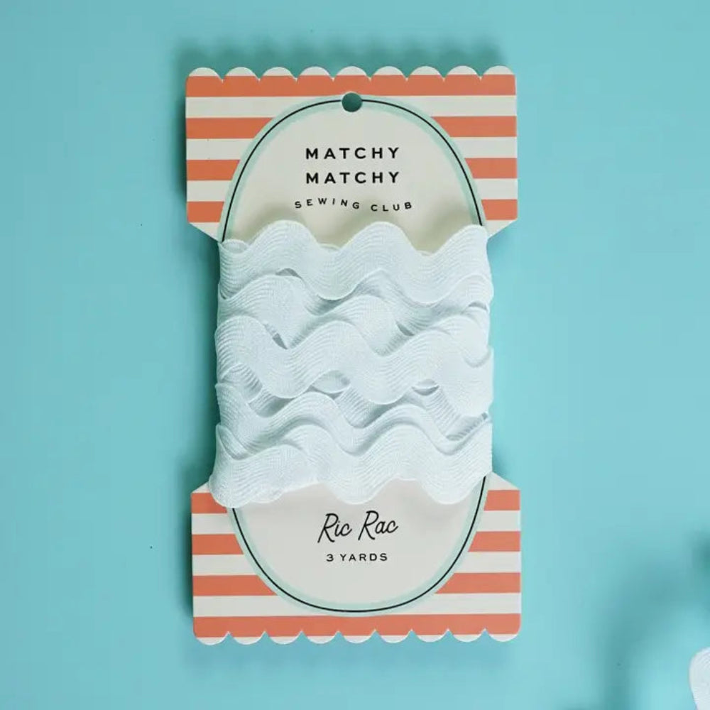 Packaged white ric rac trim with striped packaging on a light blue background